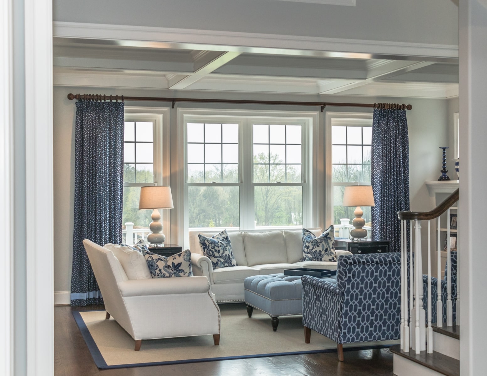 four single hung windows in a white and blue living room with a curtain in front of them.