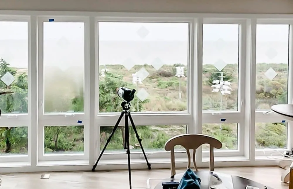telescope looking outside an array of windows